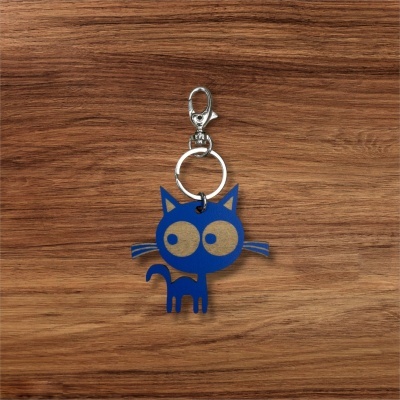 Porta-chaves em forma de gato azul com olhos grandes e detalhes em bege