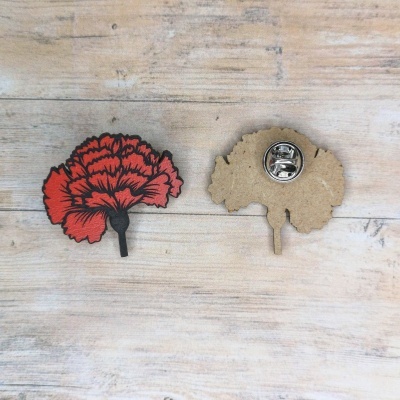 Pins de madeira em forma de flor vermelha e preta sobre madeira