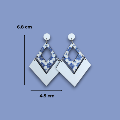 Brincos losango azul e branco com padrões azuis e branco liso, fundo azul.