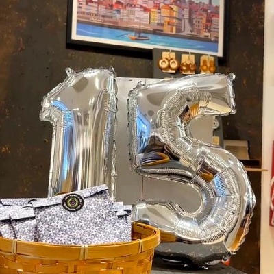 Balões prateados de número 15 em ambiente com cesto e quadro do Porto