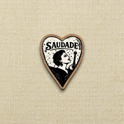 Pin coração madeira com ilustração preta e branca de mulher e guitarra e texto SAUDADE.