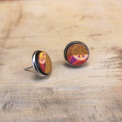 Brincos tipo tacha redondos com madeira e padrão geométrico colorido.