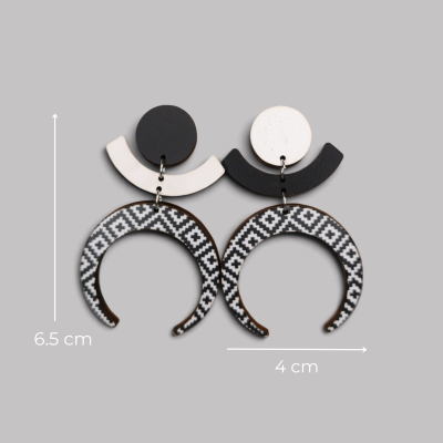 Brincos pendentes preto e branco com padrão geométrico em fundo cinzento