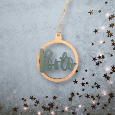 Enfeite circular de madeira com a palavra Porto em verde pendurado em fundo cinzento