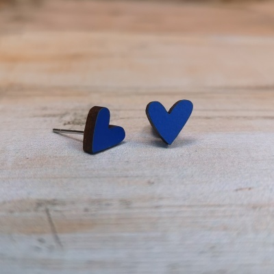 brincos azuis em forma de coração sobre madeira clara