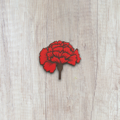 Cartão decorativo em forma de cravo vermelho sobre madeira clara