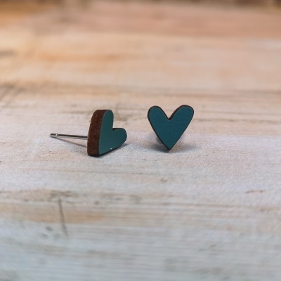 Brincos em forma de coração, verde e castanho, sobre superfície de madeira clara