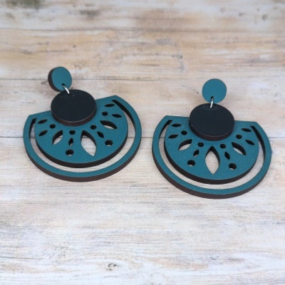 Brincos em madeira azul turquesa e preto com padrão recortado em madeira clara