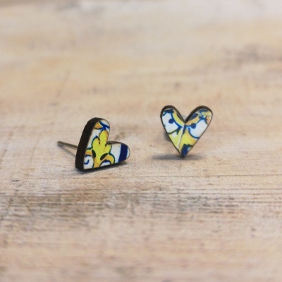 Brincos em forma de coração com padrão azul, amarelo e branco em madeira