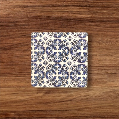 Azulejo quadrado com padrão azul e branco sobre madeira