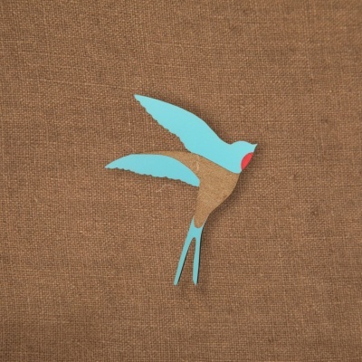 Adesivo de pássaro colorido sobre tecido castanho