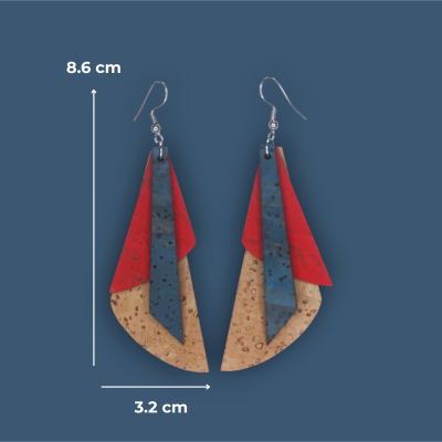 Brincos coloridos em cortiça com camadas bege, azul e vermelha sobre fundo azul.