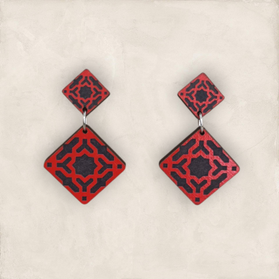 Brincos de madeira vermelhos e pretos com padrão geométrico em forma de losango
