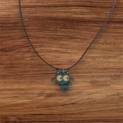 Colar com pendente de gato azul com olhos dourados sobre fundo de madeira