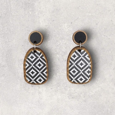 Brincos com padrão geométrico preto e branco e bordas em madeira