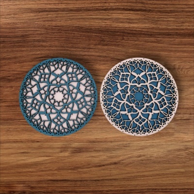 Dois tapetes redondos decorativos com padrão recortado sobre madeira