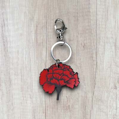 Chaveiro metálico com pendente flor vermelha em madeira clara