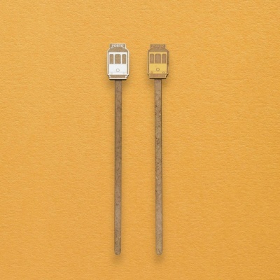 Mexedores de bebida decorativos em forma de elétrico, um branco com texto PORTO e outro amarelo.