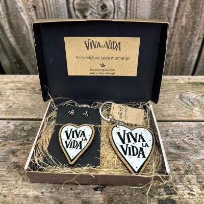 Caixa aberta com acessórios de madeira e resina com texto Viva La Vida em forma de coração.