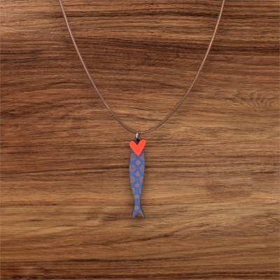 Colar com pendente de peixe azul e coração vermelho num fundo de madeira