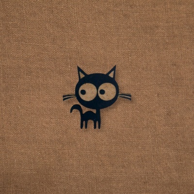 Tecido castanho com desenho preto de gato com olhos grandes