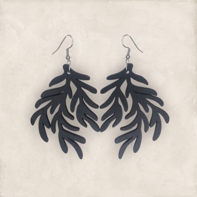 Brincos pretos em forma de folhas sobre fundo claro