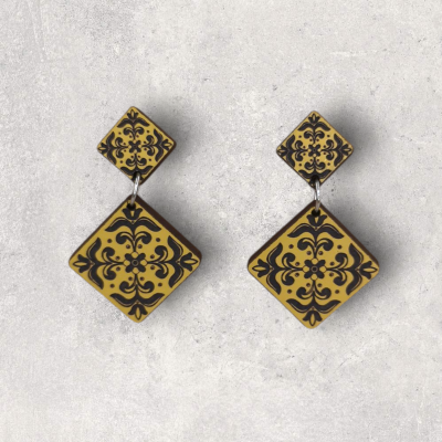 Brincos quadrados castanho com padrão preto sobre fundo cinza