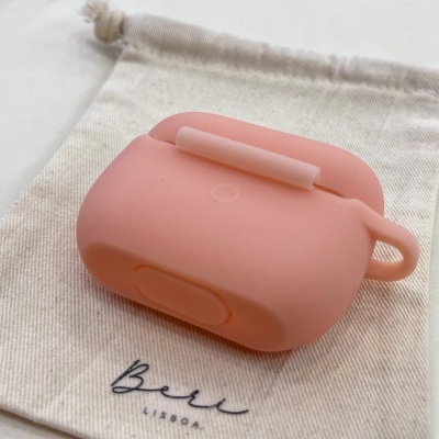 Estojo protetor rosa claro para auriculares sobre saco de tecido com texto Bell Lisboa