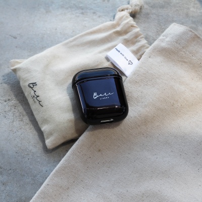 Estojo preto para auriculares wireless sobre sacas de tecido bege