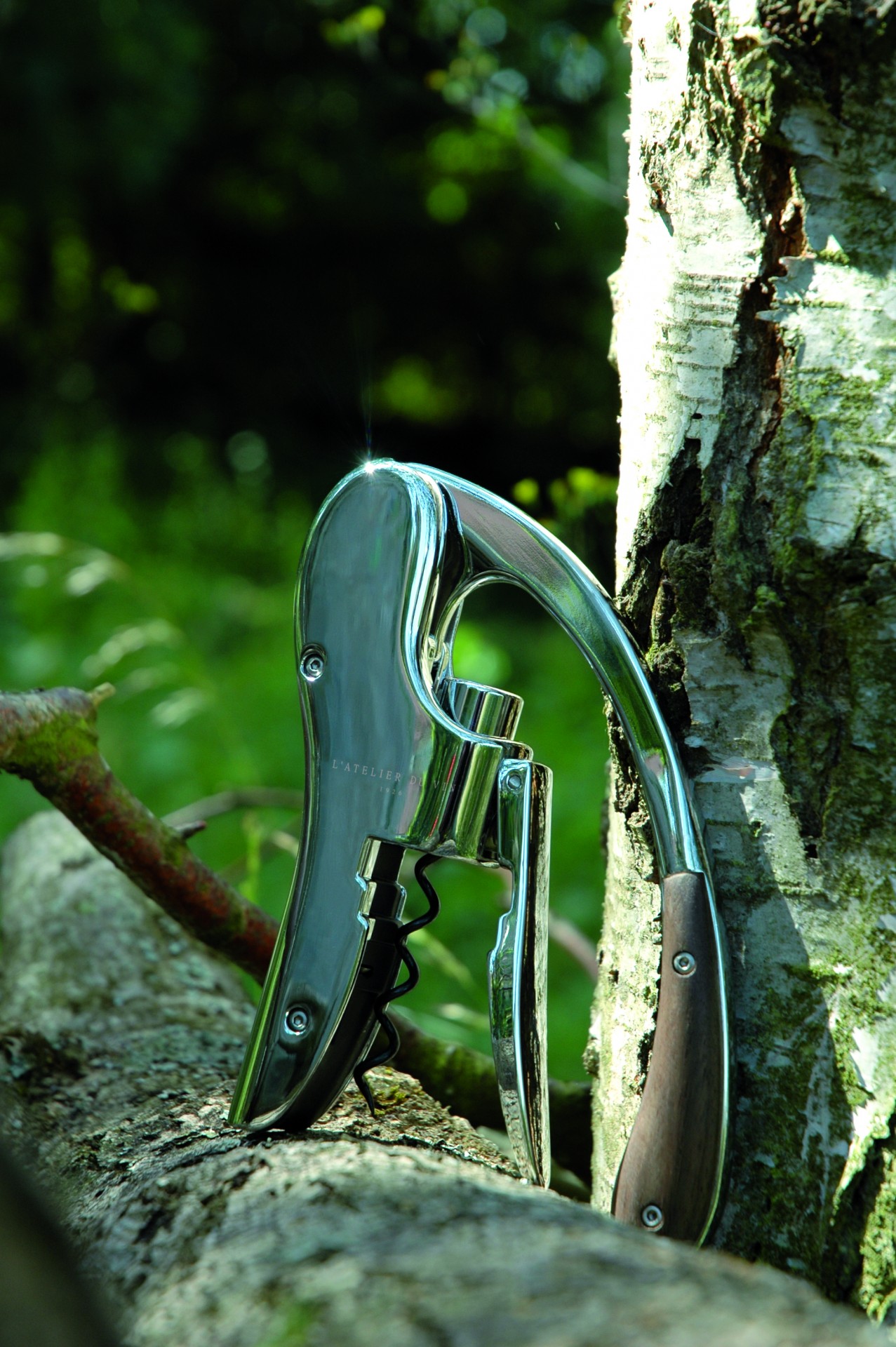 L' Atelier du Vin Saca-rolhas cromado com pega de madeira sobre tronco de árvore