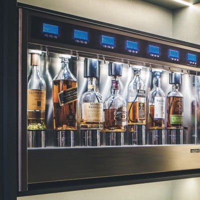 Máquina automática com garrafas de whisky em exposição iluminada