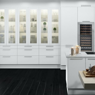 Cozinha moderna com armários brancos, vidro transparente e bancada branca