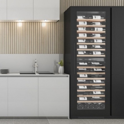 Cozinha moderna com armários brancos e pretos e painel de madeira clara na parede