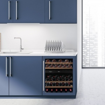 Cozinha moderna com armários azuis e adega embutida cheia de vinhos