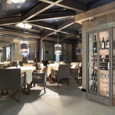 Sala de refeições moderna com armário de vinho em vidro e madeira