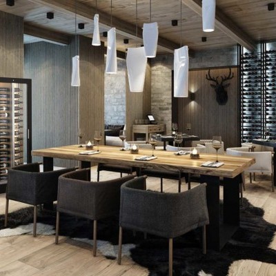 Restaurante com decoração moderna, mesas e cadeiras em madeira e tecido, paredes de pedra e prateleiras de vinho