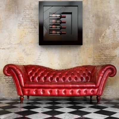 Sofá Chesterfield vermelho em pele com obra de arte preta e garrafas de vinho na parede rústica