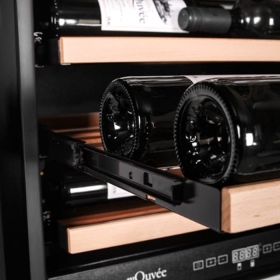 Garrafas de vinho em adega com prateleiras de madeira e controlo digital