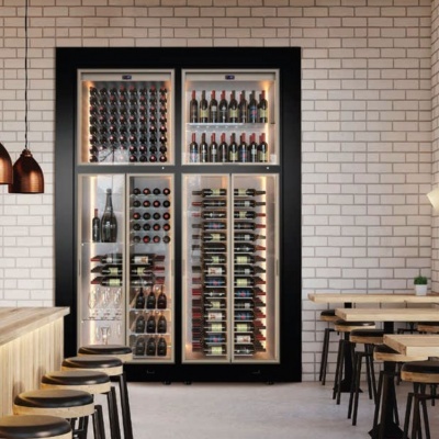 Refrigerador de vinho moderno com garrafas e iluminação embutido em parede de tijolos brancos em restaurante.