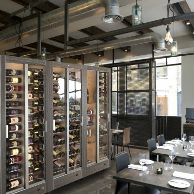 vitrine de vinhos de vidro e metal num restaurante moderno com mesas e cadeiras