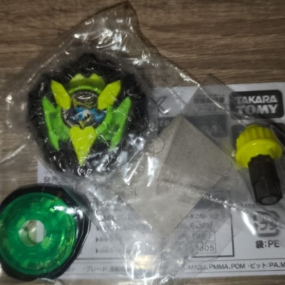 Toy parts with black, green, yellow pieces and TAKARA TOMY label on wood
