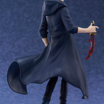 Figurine of a male character in a dark coat holding a red and gold dagger