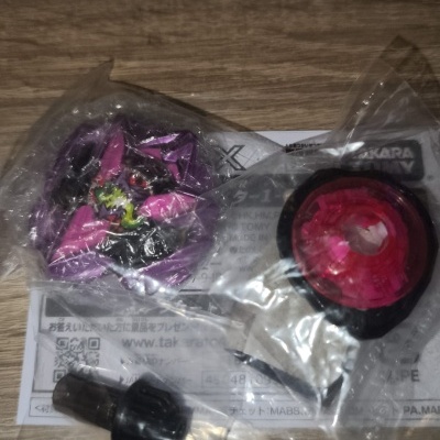 Plastic toy parts sealed in clear bags on a wooden surface with Takara Tomy label