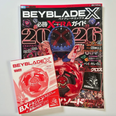 Beyblade X magazine and boxed red Beyblade toy on a white surface