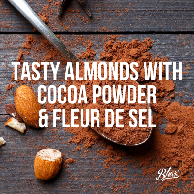 Amêndoas e pó de cacau numa colher sobre mesa de madeira escura com texto sobreposto