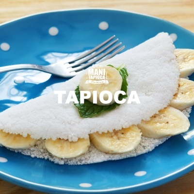 Prato azul com tapioca recheada de banana e folha verde com texto TAPIOCA