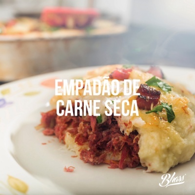 Prato com empadão de carne seca e texto EMPADÃO DE CARNE SECA