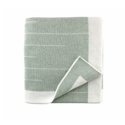 Manta verde e branca dobrada com padrão geométrico