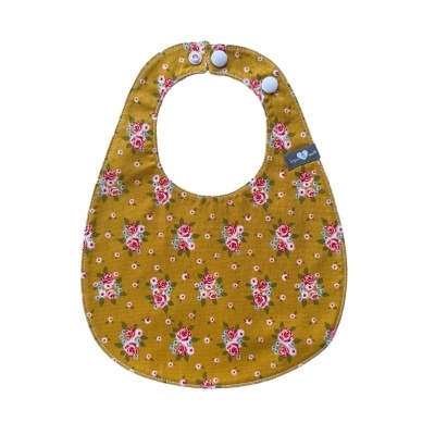 Babete de bebé amarelo com padrão floral e fecho de mola branco