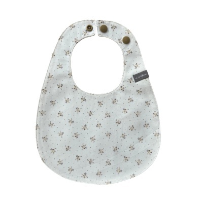 Babete de tecido branco com padrão floral bege e castanho e botões de pressão castanhos
